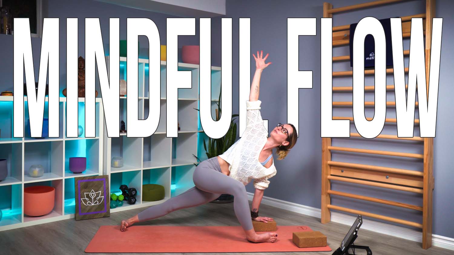 Carole Carter from Living Lotus Online on a yoga mat demonstrating revolved crescent lunge Utthita Parivritta Anjaneyasana with arms extended modified with a yoga block